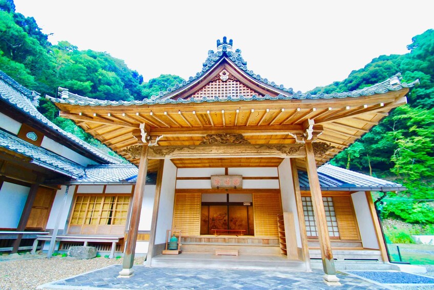A traditional Japanese temple with a tiled roof, wooden beams, and a central entrance. 4