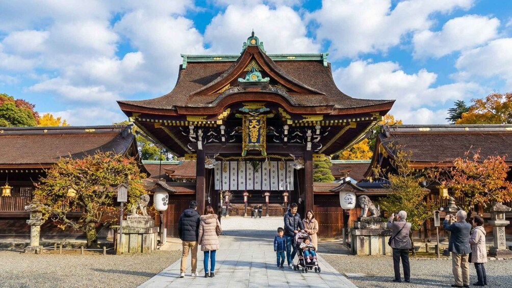 A traditional Japanese gate with visitors and a child stroller in front. 4