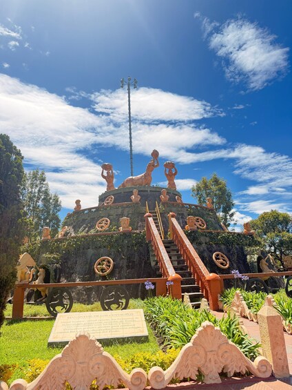 A historical site with statues, a staircase, and a plaque. 5
