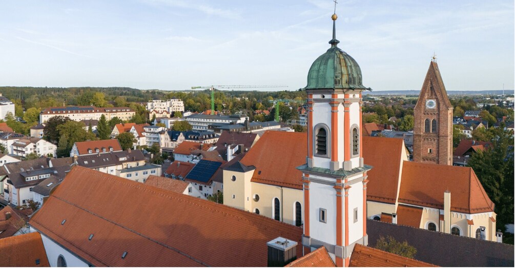 A town with a prominent church tower and a smaller church with a green dome. 3