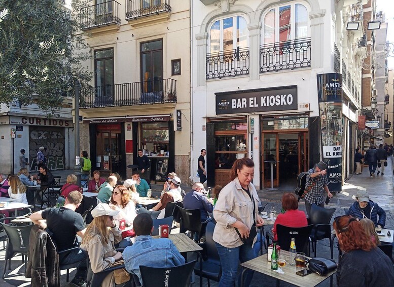 Outdoor seating at a café with people dining and a man playing guitar. 2