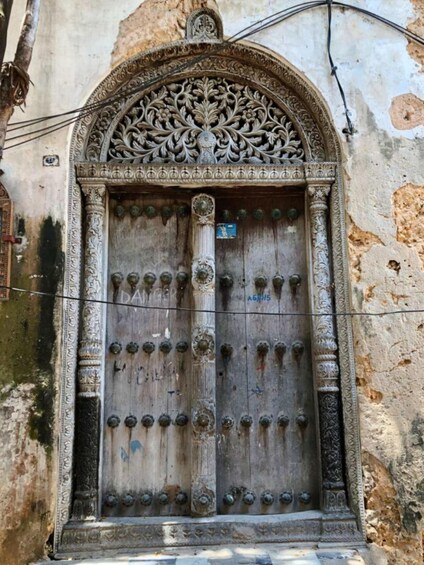 Un'elaborata porta in legno con sculture intricate e stipiti in metallo. 3