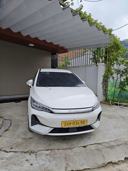 Une voiture blanche est garée devant une maison qui a un garage. 3