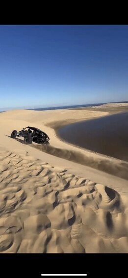 A quad bike on a sandy dune with a clear sky. 2
