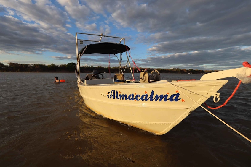 A boat named Almacalma on calm water with a cloudy sky. 2
