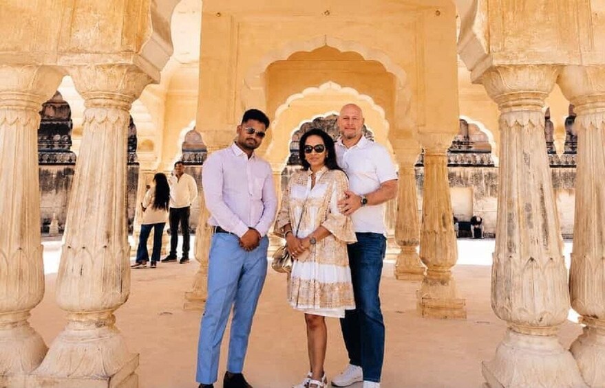 A group of people standing in a historical building with ornate arches and columns. 5