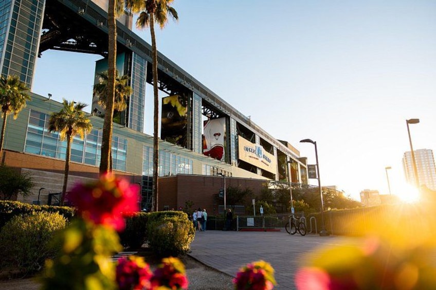 A modern building with a large sign, palm trees, and flowers in the foreground. 4