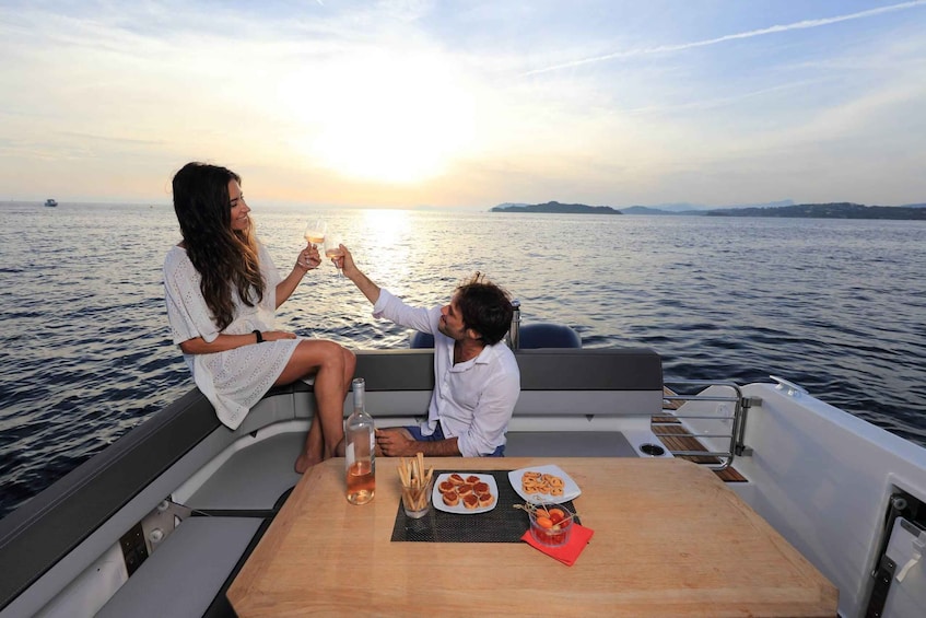 A couple toasting on a boat with a sunset in the background. 1