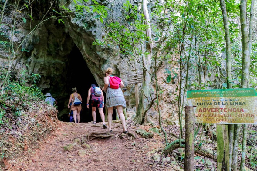 A cave entrance with hikers approaching. 3