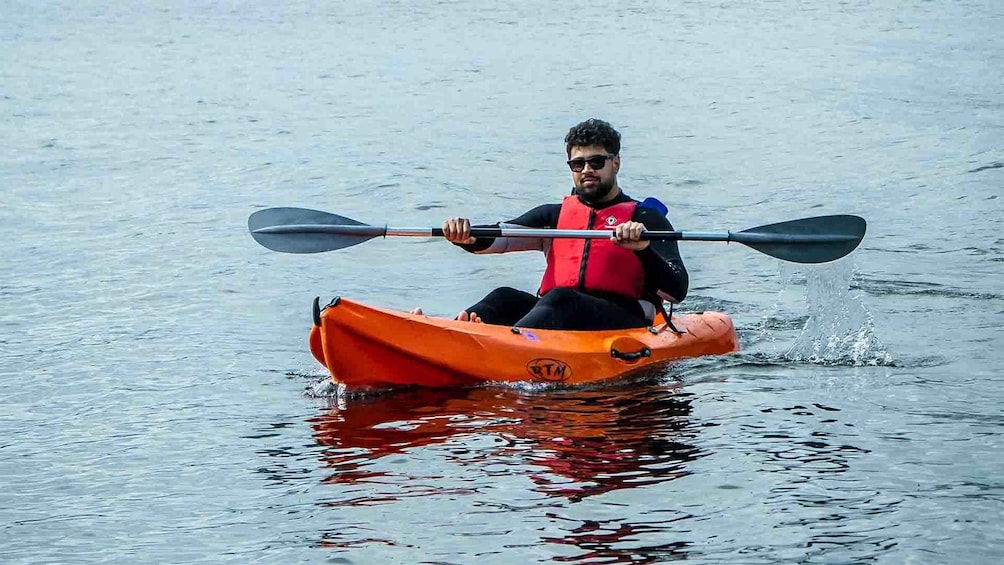 A person kayaking on calm water. 4