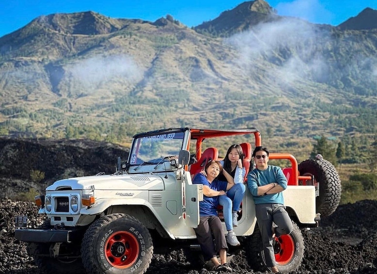 A white off-road vehicle with red accents parked on a rocky terrain with a mountainous backdrop. 4