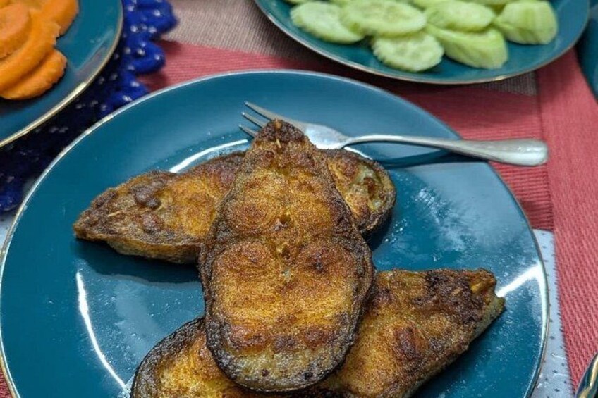 A plate of fried fish with a fork on a blue plate. 3