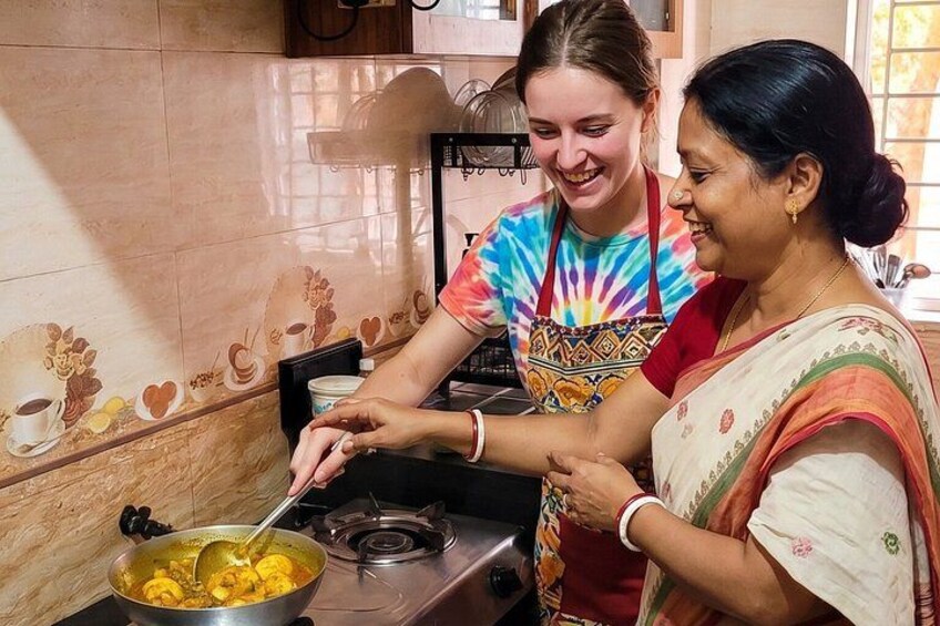 Two people cooking together in a kitchen with a tiled backsplash. 1