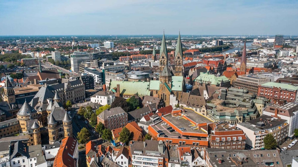 A cityscape with historic buildings, a prominent church with a tall spire, and a river in the background. 3