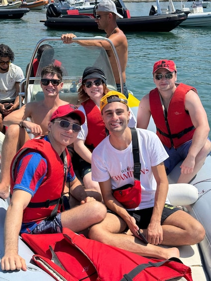 A group of people on a boat, wearing life jackets and casual clothing. 3
