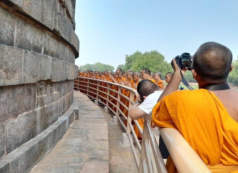 Monks in orange robes lining a stone pathway. 1