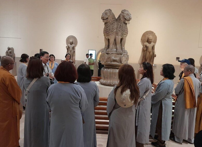 A group of people in a museum, observing statues and a large decorative fountain. 5
