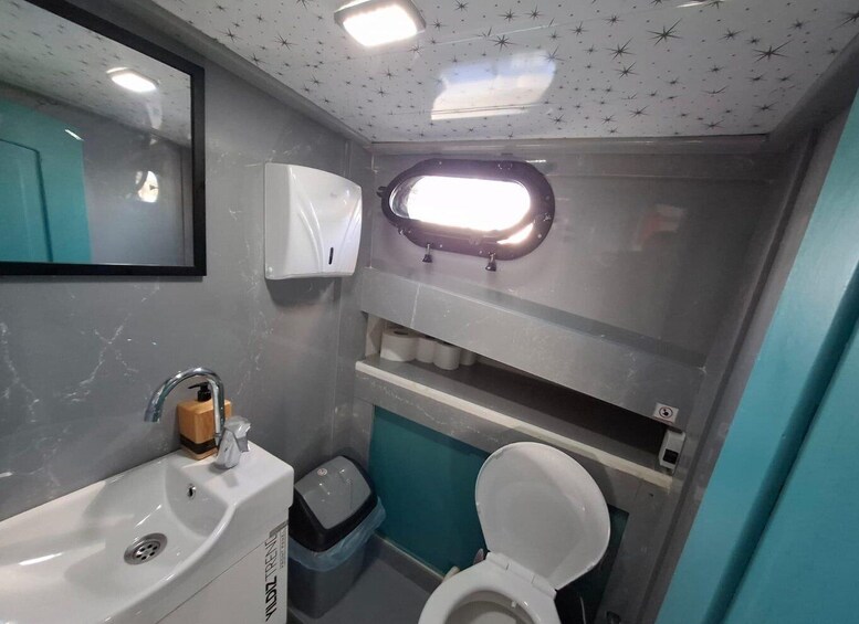 A compact bathroom with a sink, toilet, and a mirror. 3
