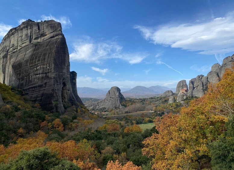 Un paisaje montañoso con formaciones rocosas destacadas y árboles de colores otoñales. 1
