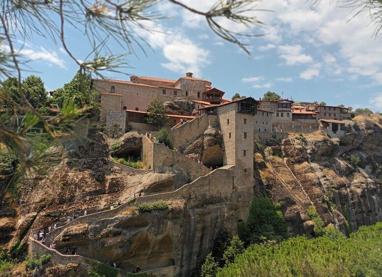 Una fortaleza de piedra histórica con senderos escalonados y edificios en una ladera. 5