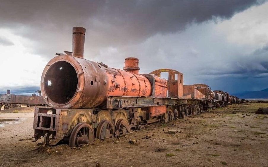 An abandoned, rusted train engine in a desolate landscape. 5