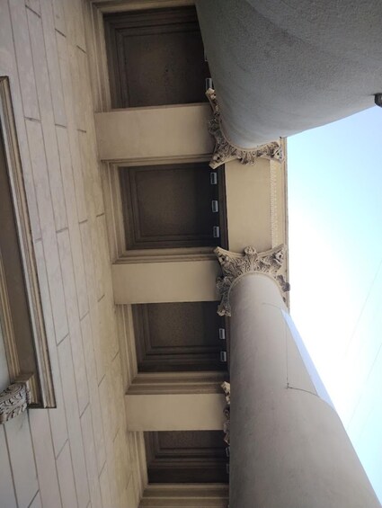 A building facade with classical columns and a large door. 2