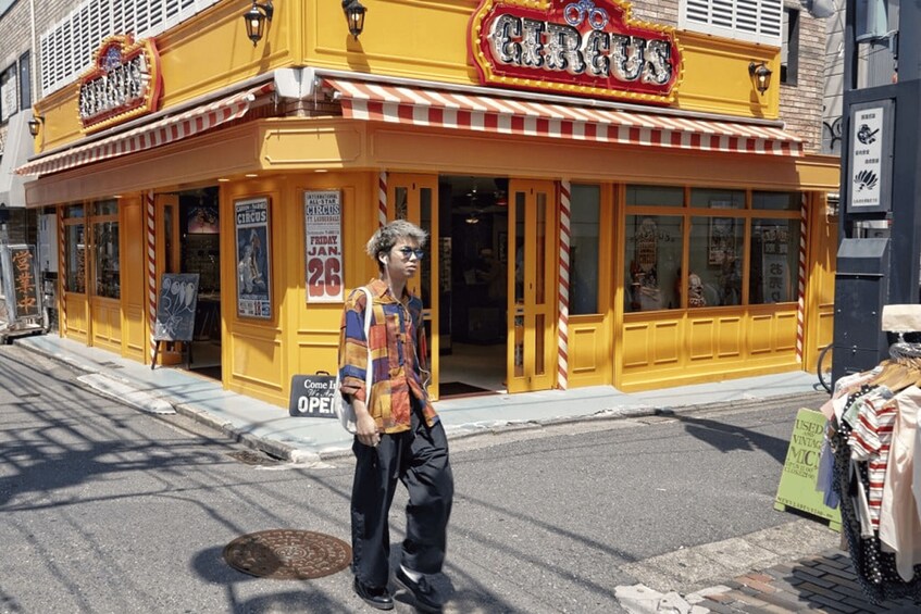A yellow building with a sign that reads 'Circus' and a man standing in front. 2