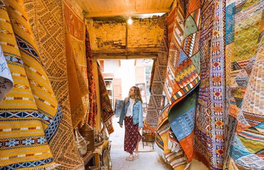 A narrow alley lined with colorful textiles and traditional pottery. 5