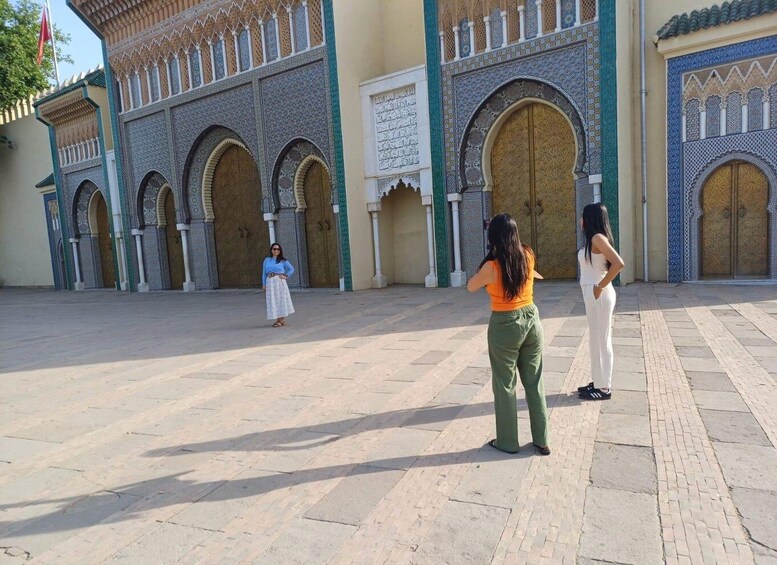 A courtyard with ornate arches and a large, intricately designed gate. 3