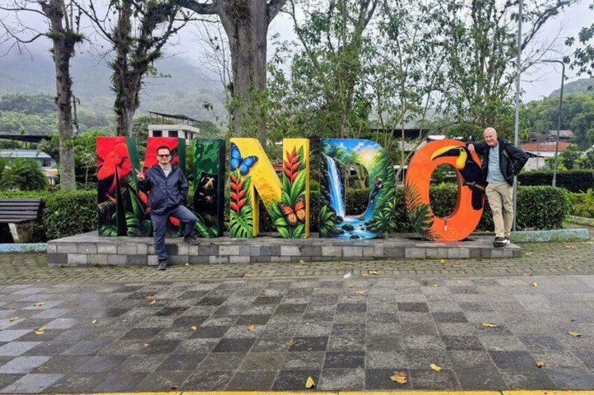A man standing in front of a colorful outdoor art installation spelling 'INDO.' 4