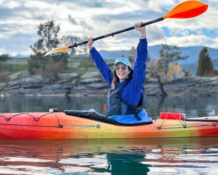 A person kayaking on a calm river with a mountainous landscape in the background. 2