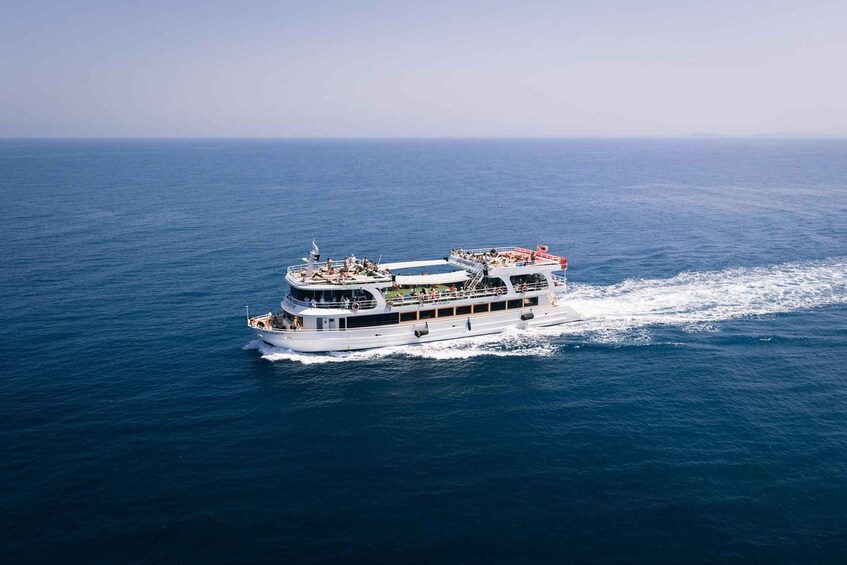 A large white cruise ship with multiple decks and passengers enjoying the ocean view. 3