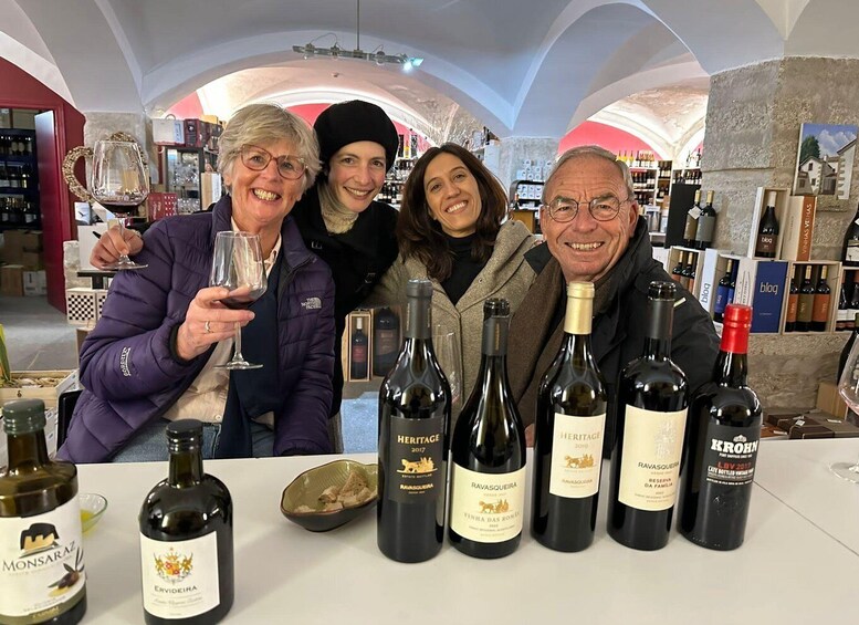 A group of people in a wine shop with various bottles of wine on display. 4