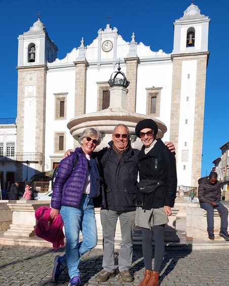A historic church with a clock tower and a fountain in front. 2
