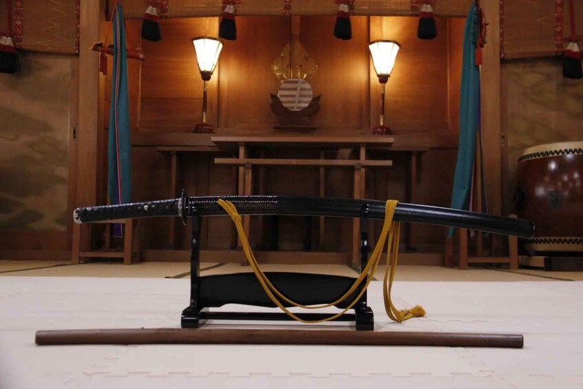 A traditional Japanese sword on a stand with two lamps in the background. 4