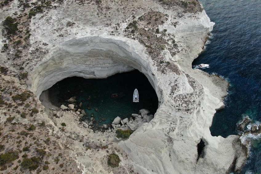 Une vaste ouverture de grotte, entourée d’un paysage rocheux et donnant sur la mer. 3
