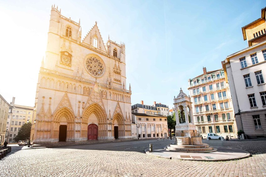 A historic cathedral with Gothic architecture, a cobblestone square, and surrounding buildings. 3