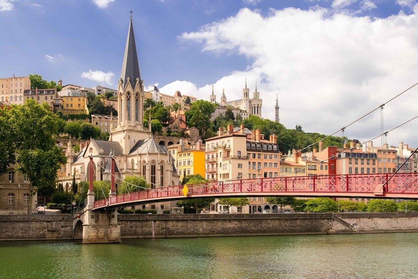 A red bridge over a river, historic buildings, and a church with a tall spire. 2