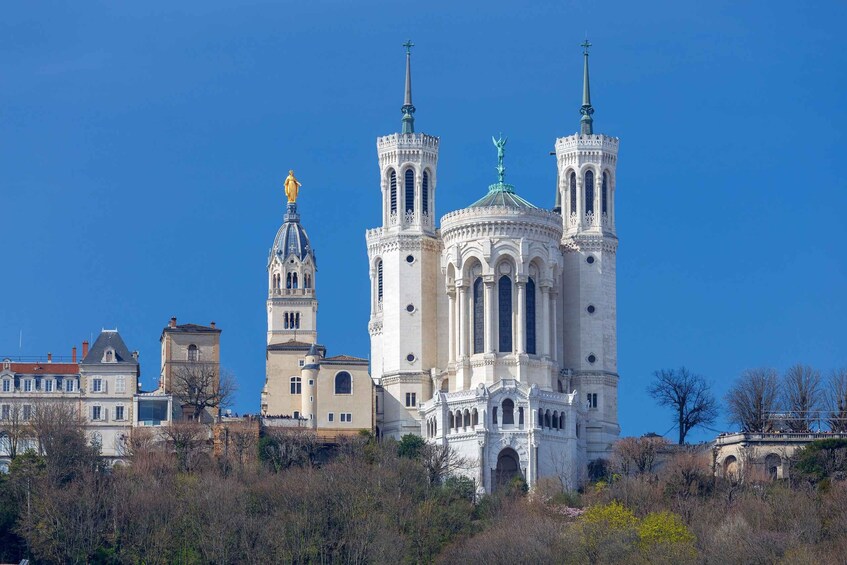 A historic cathedral with two tall towers and a dome, surrounded by buildings and trees. 1