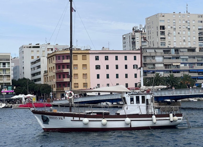 A boat named 101113 PR docked at a marina with buildings in the background. 3