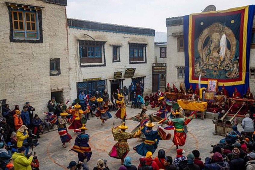 A traditional dance performance in a courtyard surrounded by buildings. 4