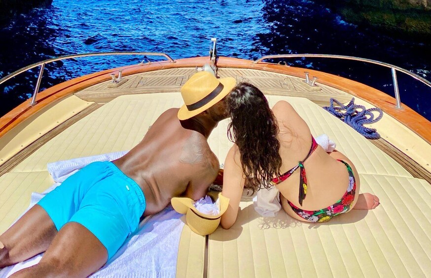 Un couple se prélasse au soleil sur un bateau doté d’un pont en bois et de cordes. 1