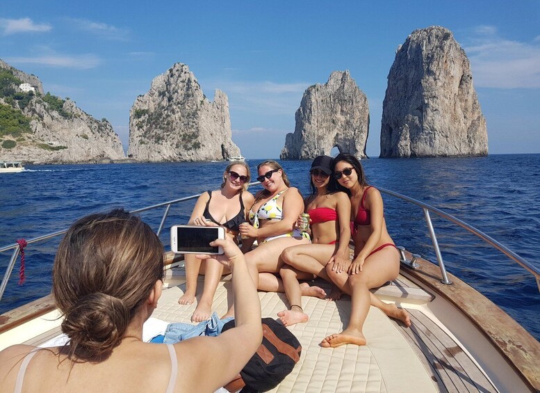 Un groupe de personnes se trouve sur un bateau, avec des falaises rocheuses en arrière-plan. 5