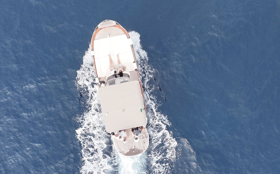 Une vue aérienne d’un bateau naviguant sur l’océan, laissant une vague derrière lui. 2