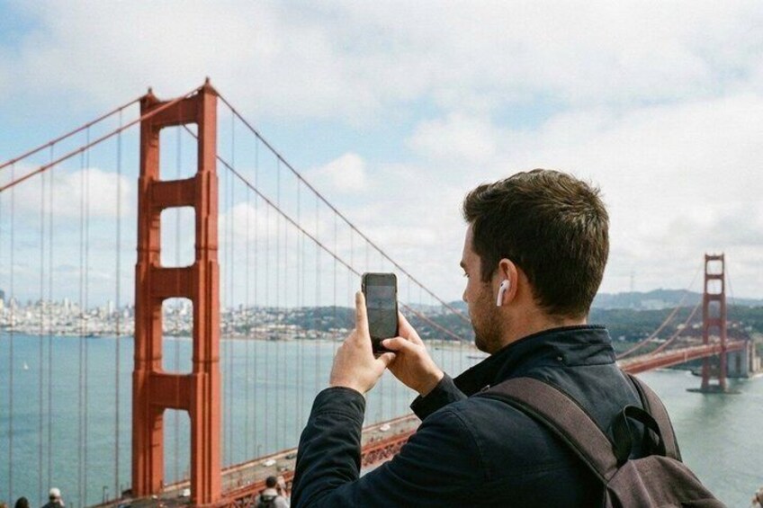 A person taking a photo of the Golden Gate Bridge. 5