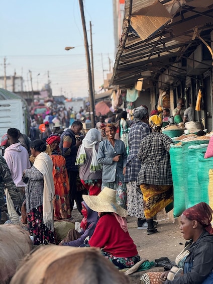 A crowded market with people shopping and vendors selling goods. 1