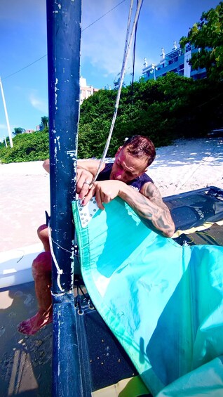 A person working on a surfboard on a beach. 3