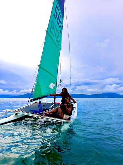A sailboat with a green sail on a calm sea. 1
