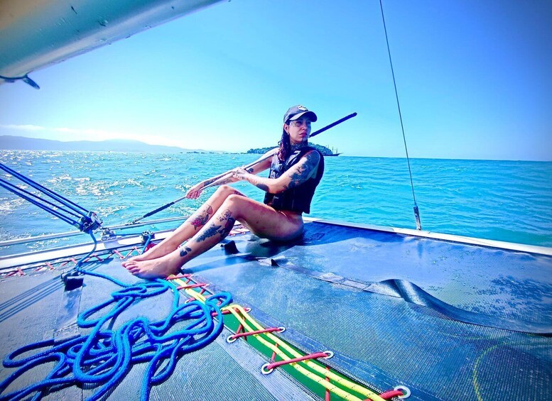 A person on a sailboat with a view of the sea and distant land. 5