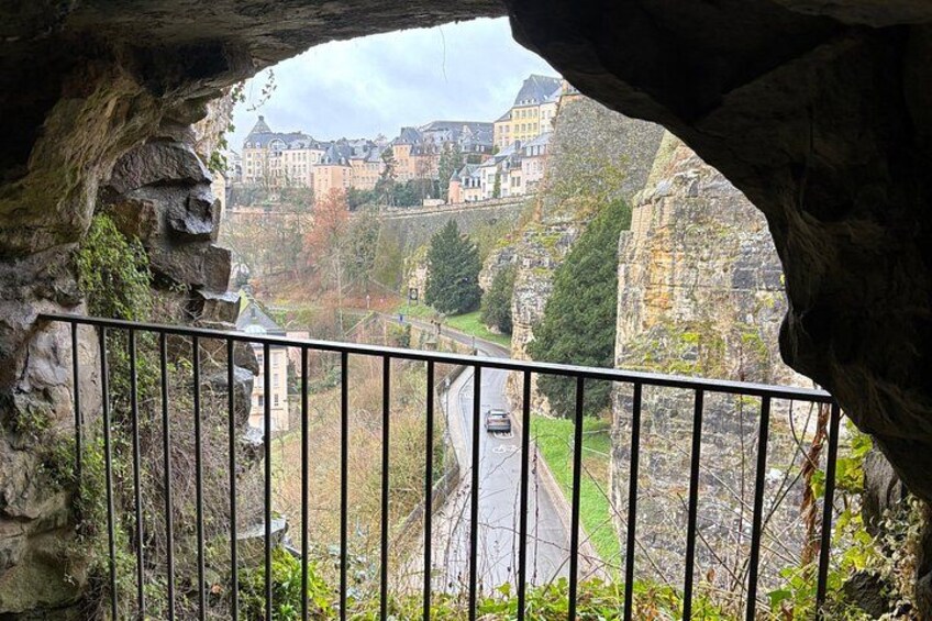 A stone archway overlooking a road with buildings in the distance. 2